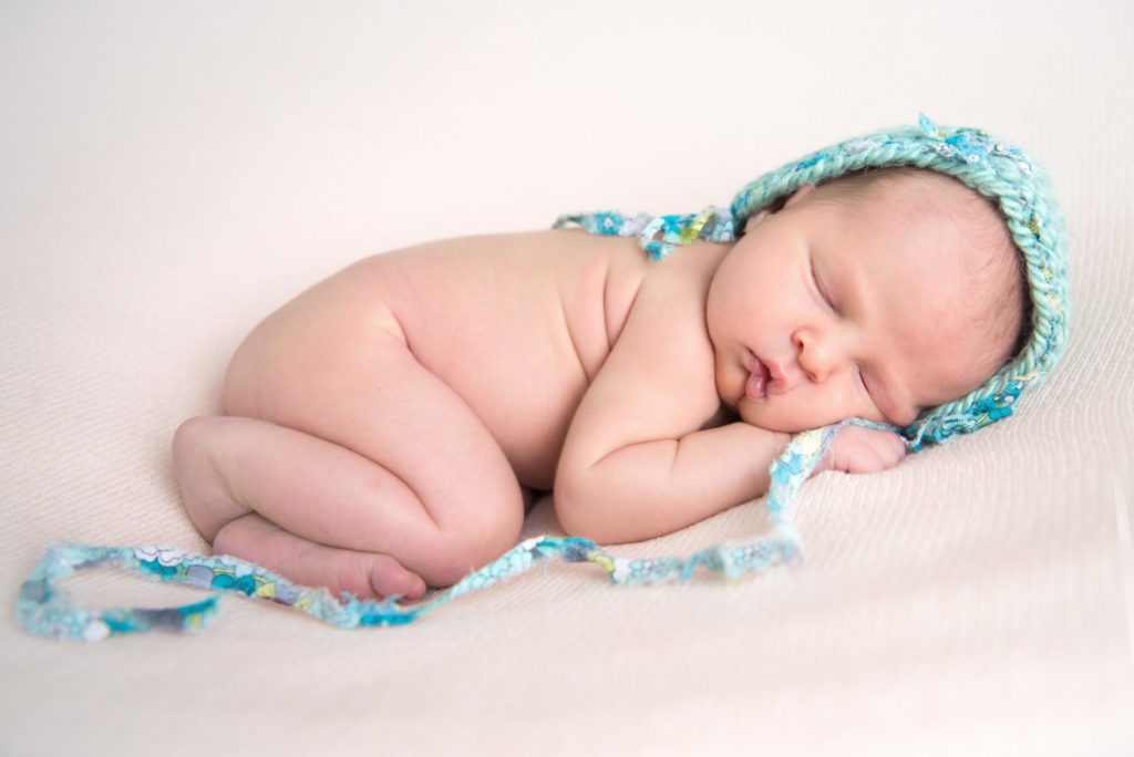 newborn baby girl in blue bonnet