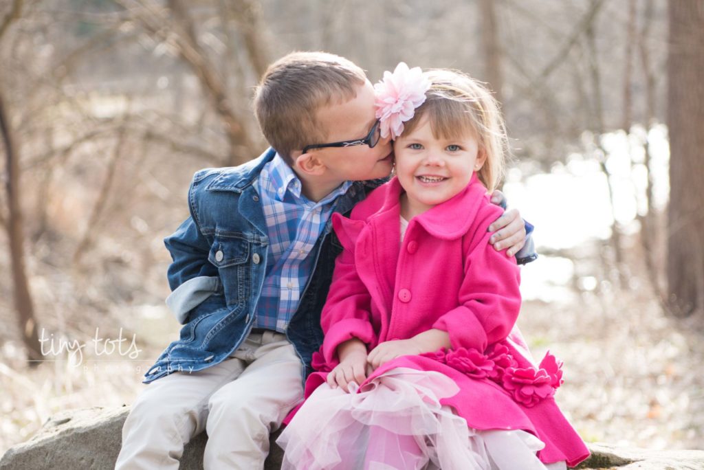 big brother kissing sister at a family photo session