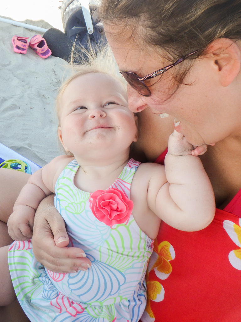 baby smiling at mom on the beach