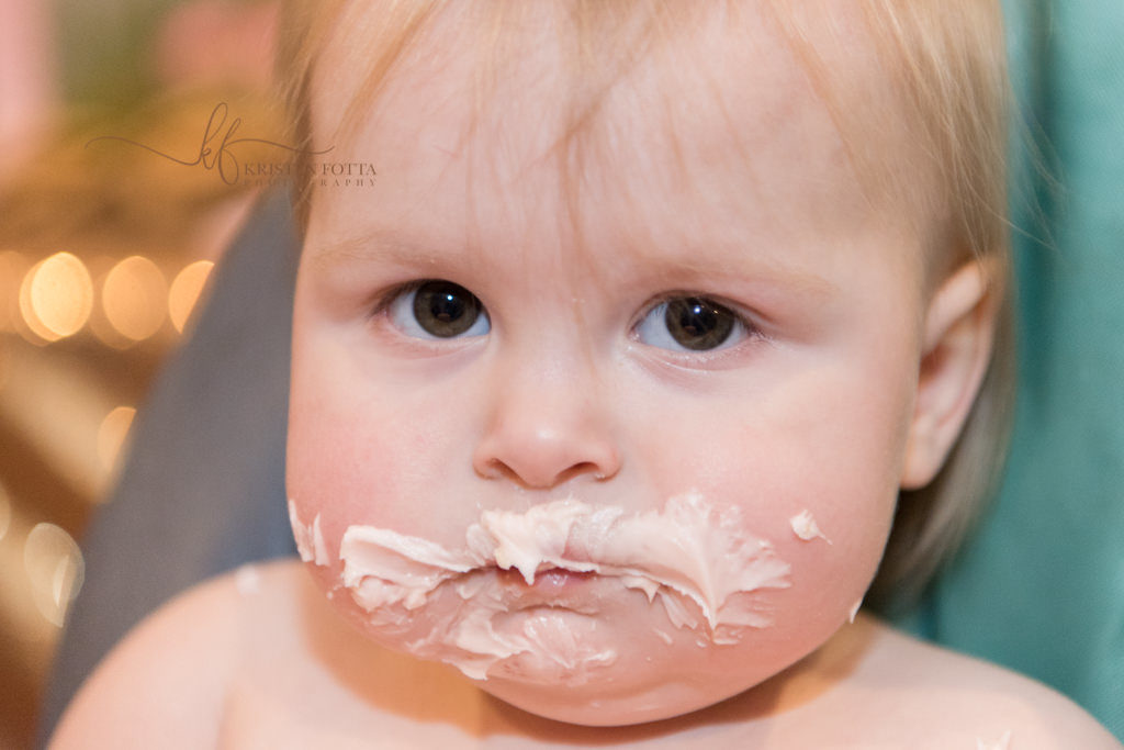 baby with cake smeared all over face