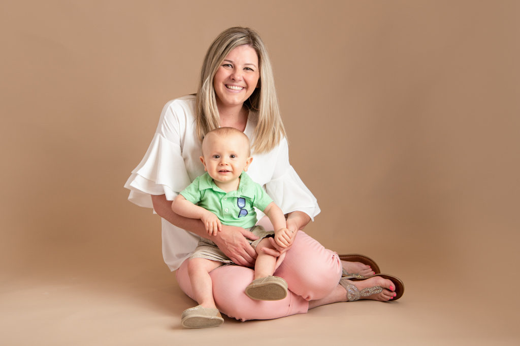 mom holding one year old baby boy during studio photography session